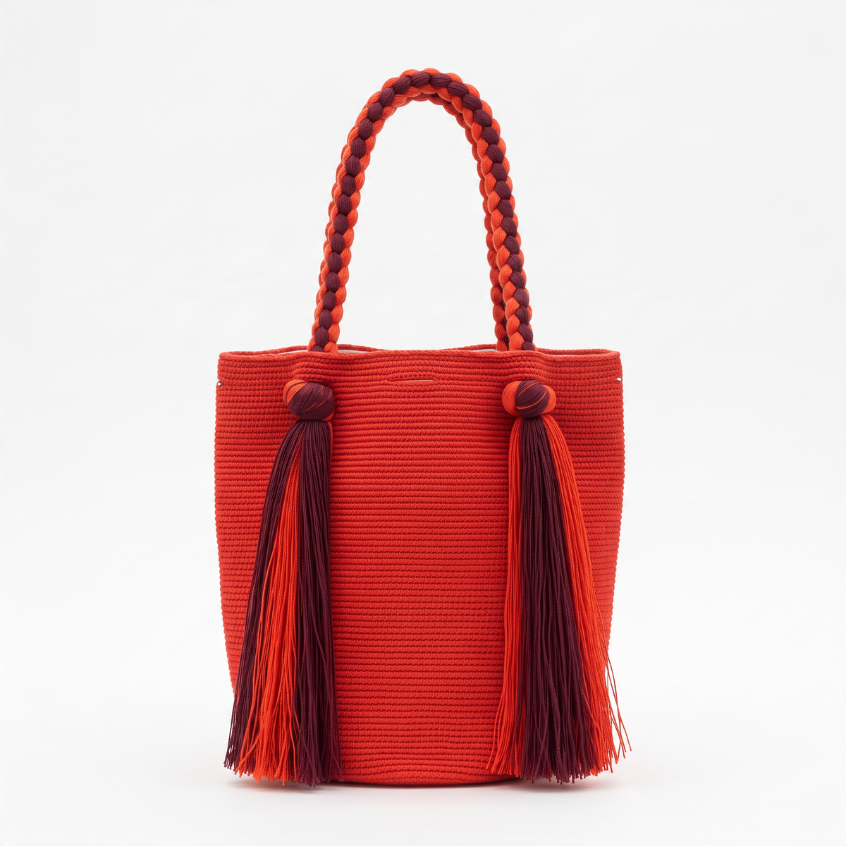 Bolso Wayúu LamuJoyas de algodón tejido a mano en color rojo con asas trenzadas y borlas decorativas.